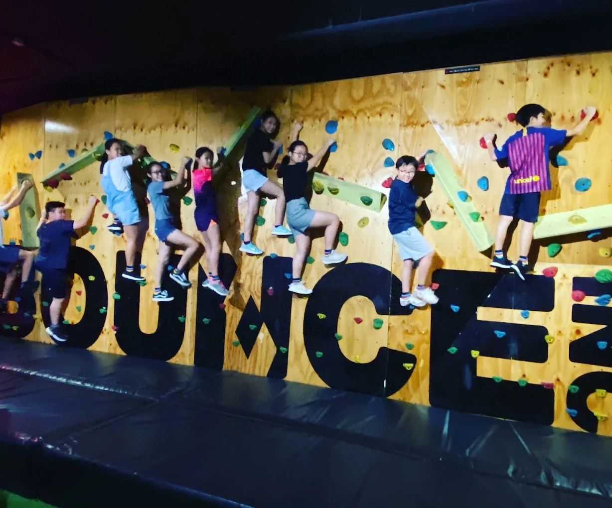 Students climbing the BOUNCE bouldering wall together