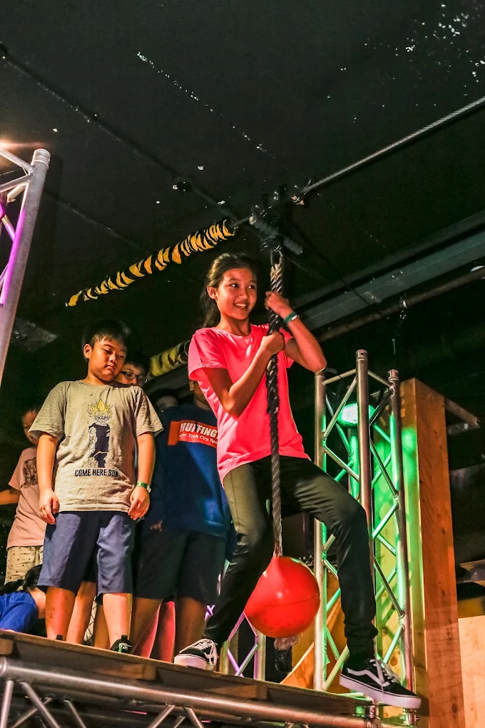 Student climbing rope at the camp ninja course